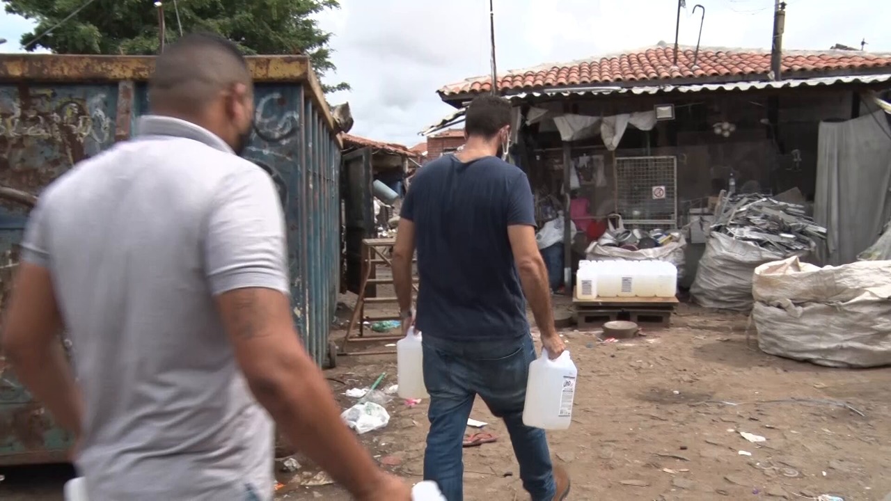 homens carregando garrafas de álcool gel